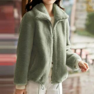 Manteau polaire femme en fausse fourrure verte, avec col montant, porté par une femme. La fermeture éclair est ouverte.