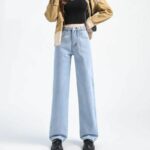 Mannequin debout sur un fond blanc, portant un jean large bleu clair à taille haute avec des boutons décoratif.