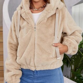 Mannequin portant une veste en fausse fourrure beige zippé, avec une poche et une capuche. Elle a la main dans la poche.