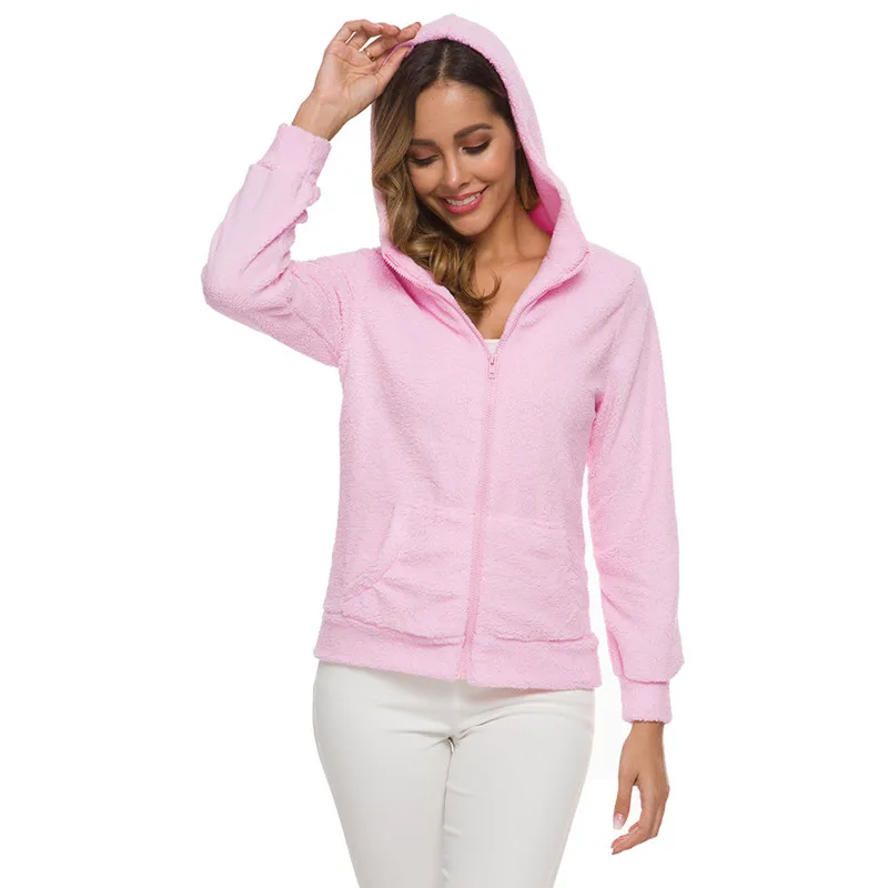 Mannequin femme debout, portant un pantalon blanc, et une veste polaire rose à capuche et fermeture éclair. On ne voit pas ses jambes, un bras est le long du corps et l'autre tien la capuche qu'elle a sur la tête. La veste est fermée. Derrière le fond est blanc.